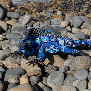 Escultura de forma de iguana cubierta con chaquira de colores azul y blanco
